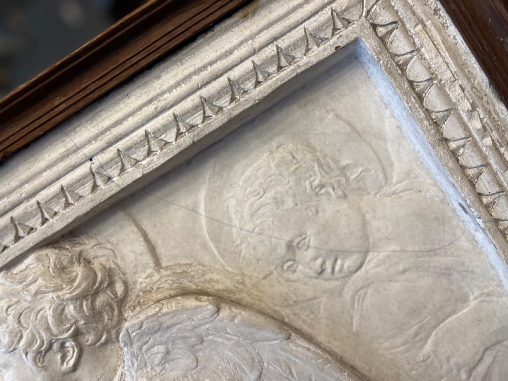 An off-white 19th-century plaster bas-relief panel depicting Christ supported by angels, framed within an inner egg-and-dart moulding and dark timber outer frame. View VIII