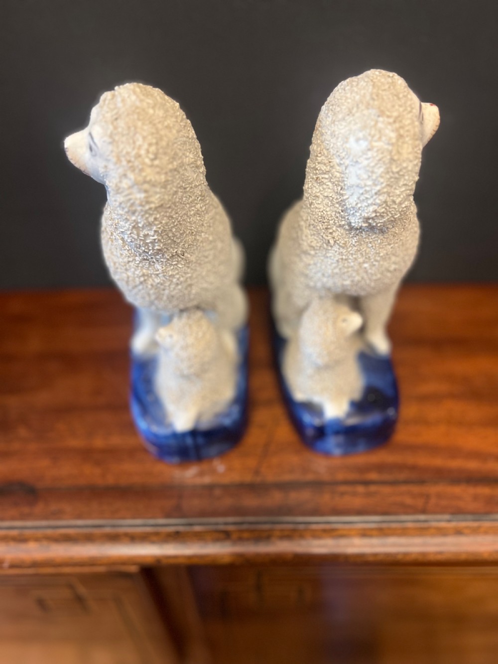 Pair of Staffordshire pottery poodles sat with their puppies  View III