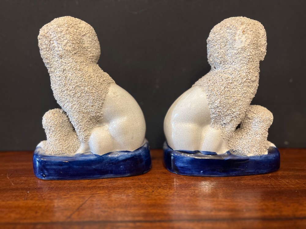 Pair of Staffordshire pottery poodles sat with their puppies  View VI