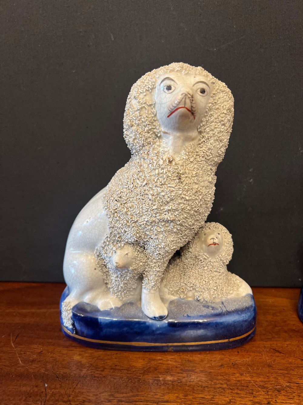 Pair of Staffordshire pottery poodles sat with their puppies  View IX