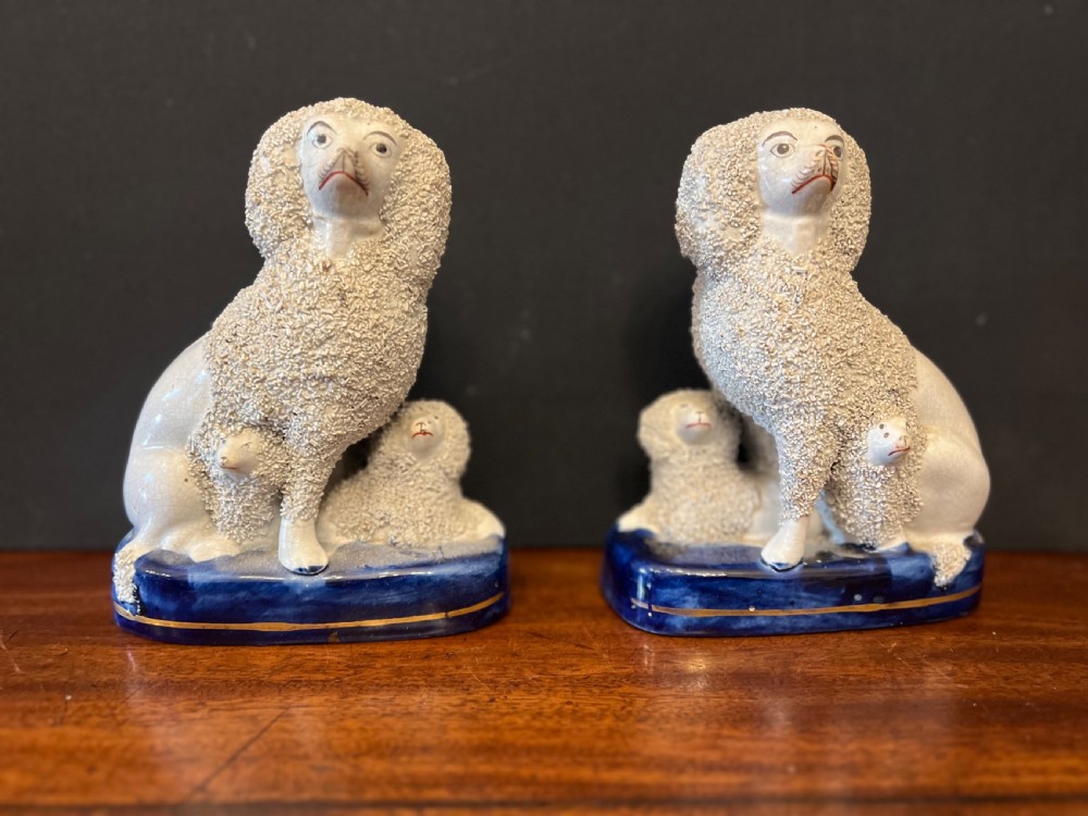 Pair of Staffordshire pottery poodles sat with their puppies  View X