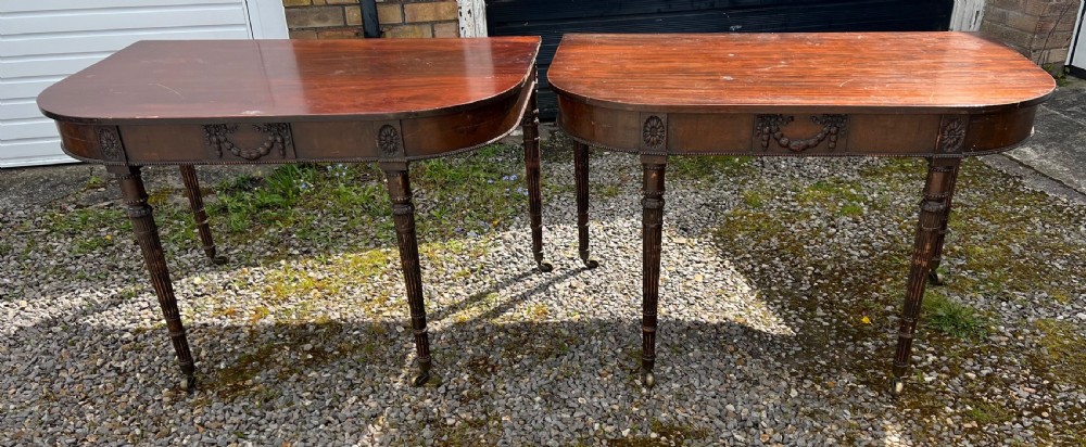 A pair of c1800 D end tables with ribbon swag carving and paterae