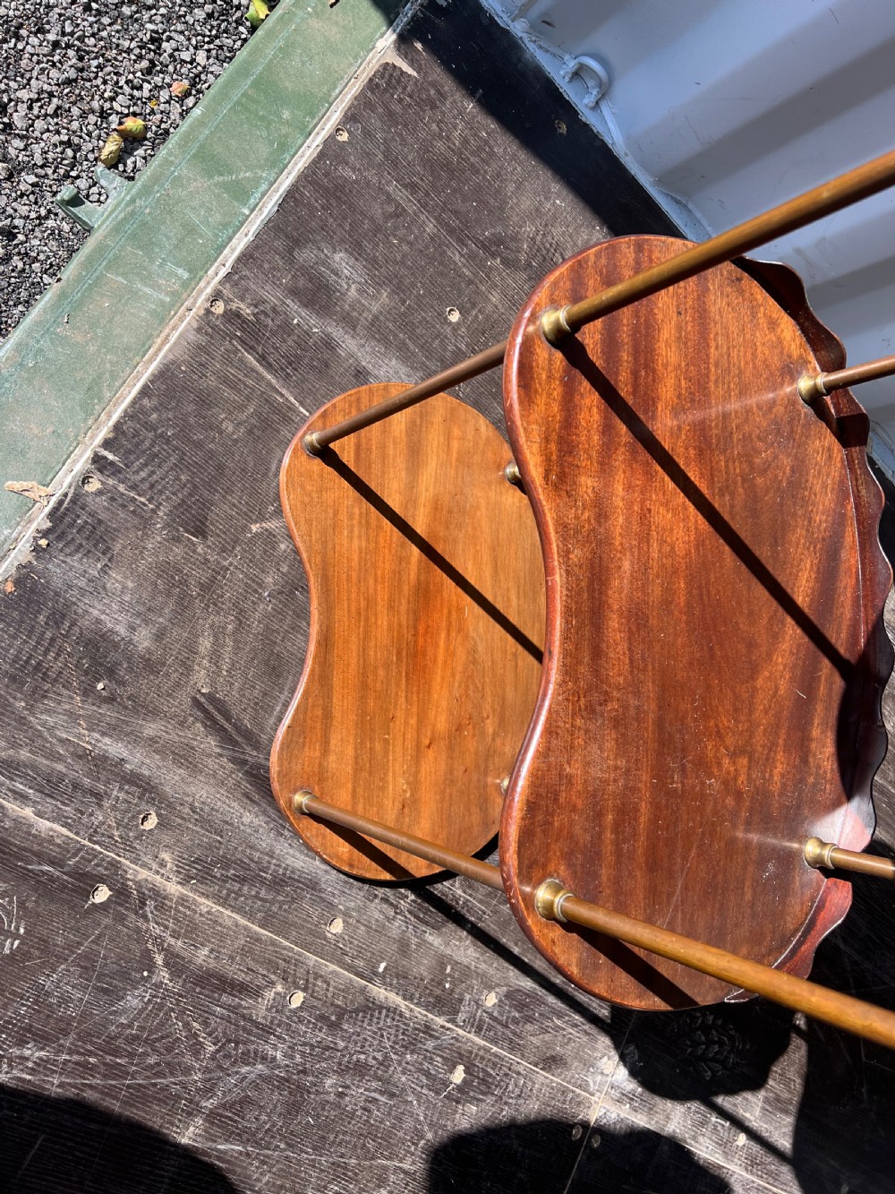 A 19th-century three-tiered mahogany kidney-shaped washstand supported by polished brass upright columns and topped with a gallery edge. View IV