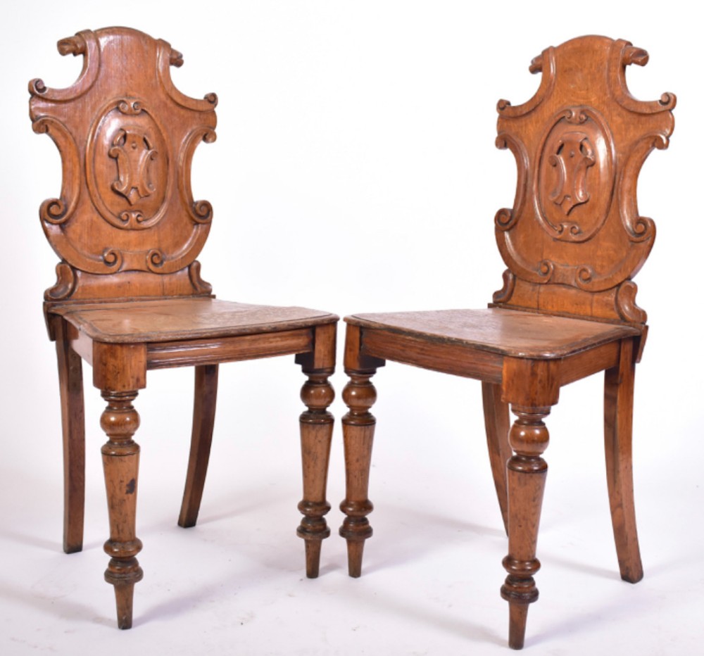 Pair of oak armorial hall chairs 