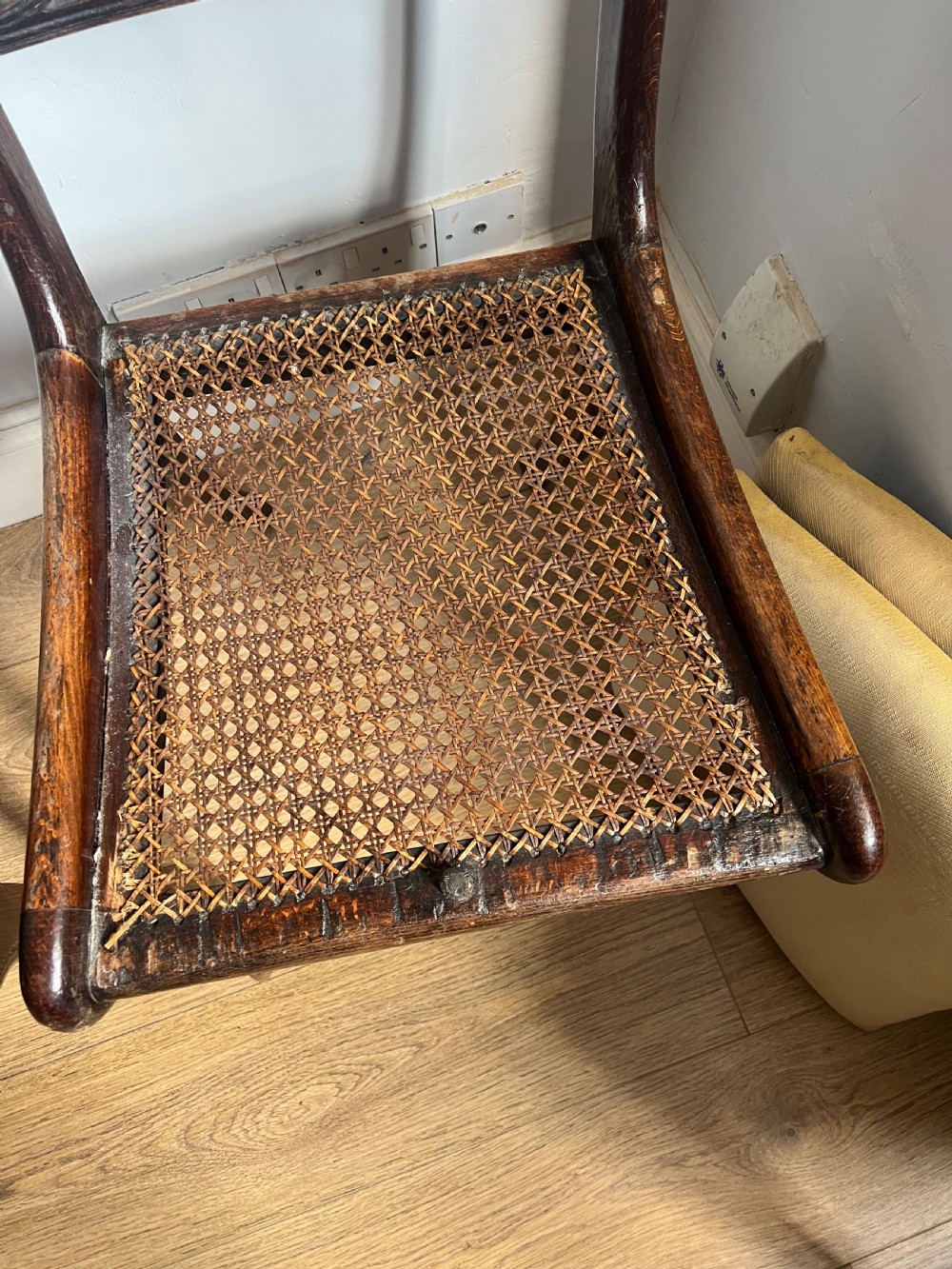 A pair of Regency faux rosewood side chairs featuring brass inlaid crest rails, carved anthemion splats, sabre legs, and pale yellow upholstered seats. View V