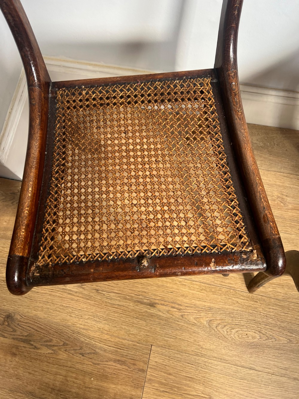 A pair of Regency faux rosewood side chairs featuring brass inlaid crest rails, carved anthemion splats, sabre legs, and pale yellow upholstered seats. View VI