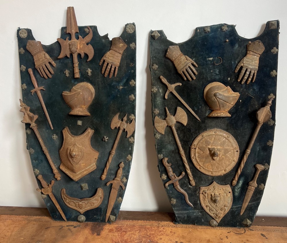 C19th display of miniature weapons in cast iron mounted on a velvet covered board 