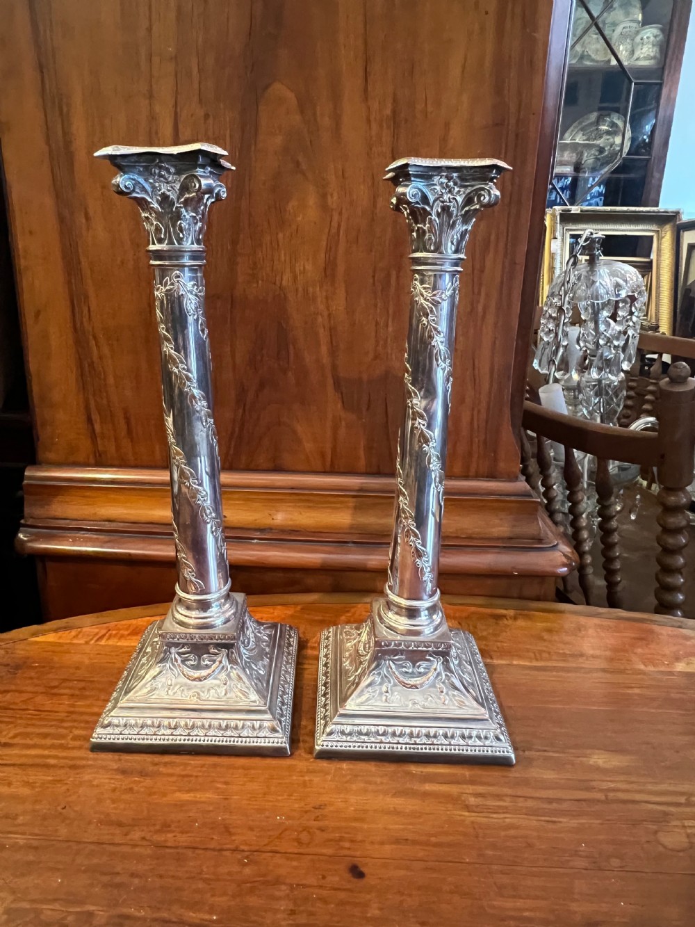 Pair of silver plate on copper Corinthian topped candlesticks 