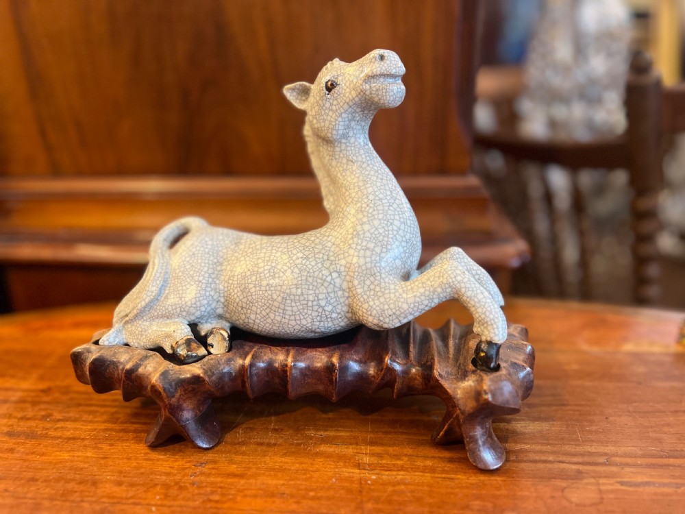 Japanese crackleglazed ceramic horse on carved wooden stand