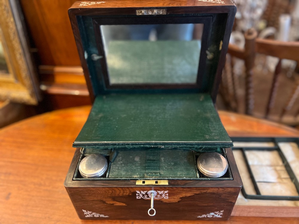 An open Victorian rosewood workbox featuring floral mother of pearl inlay, fitted green velvet interior, silver-toned vanity jars, glass bottles, and two small keys. View VIII