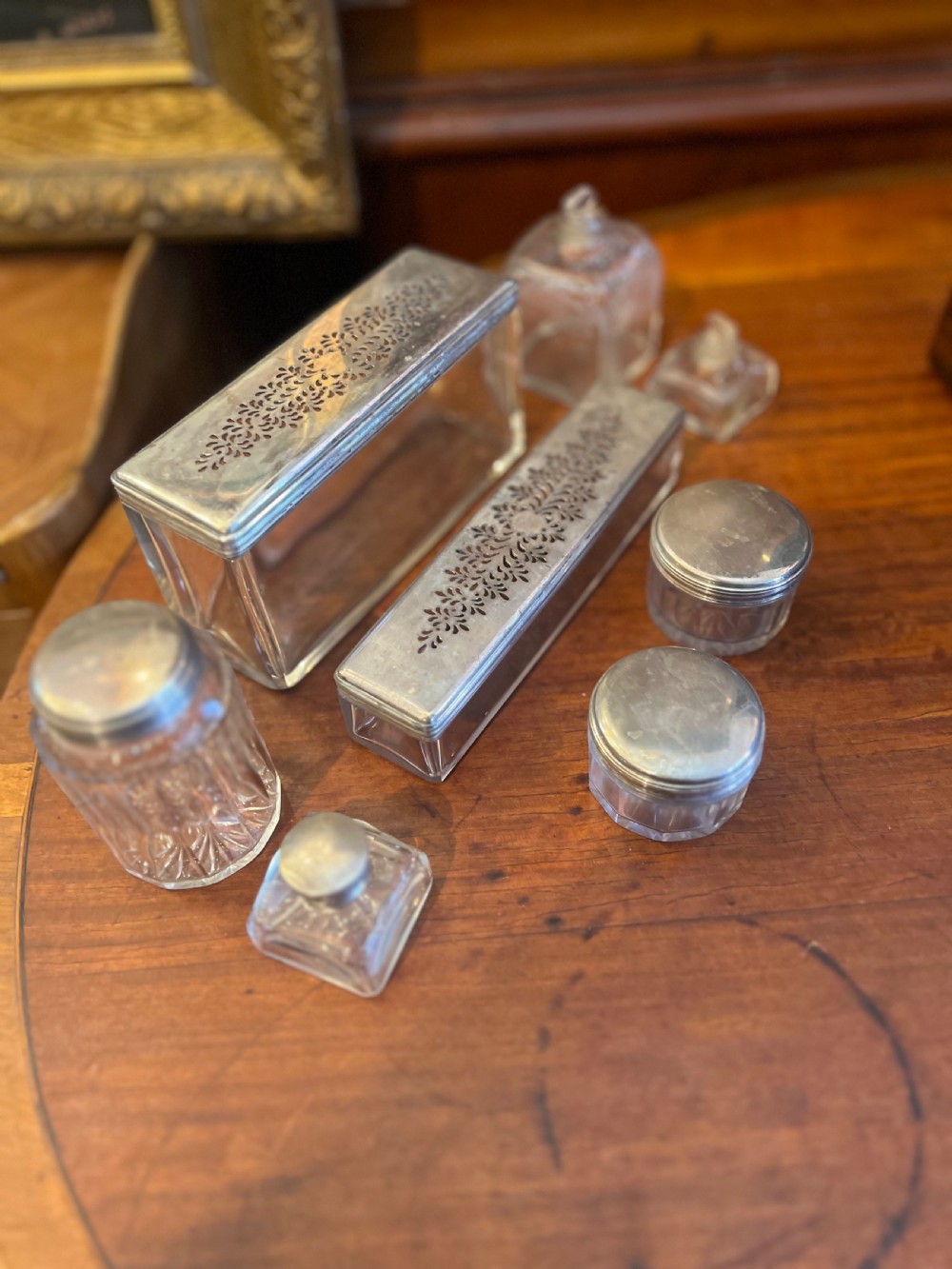 An open Victorian rosewood workbox featuring floral mother of pearl inlay, fitted green velvet interior, silver-toned vanity jars, glass bottles, and two small keys. View XV