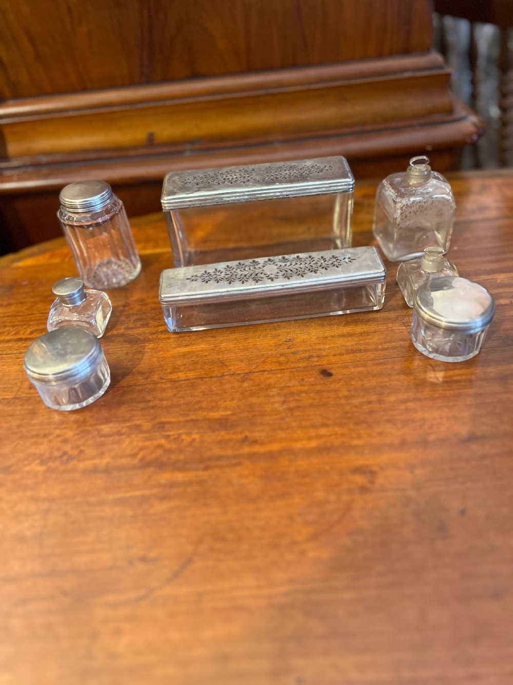 An open Victorian rosewood workbox featuring floral mother of pearl inlay, fitted green velvet interior, silver-toned vanity jars, glass bottles, and two small keys. View XVIII