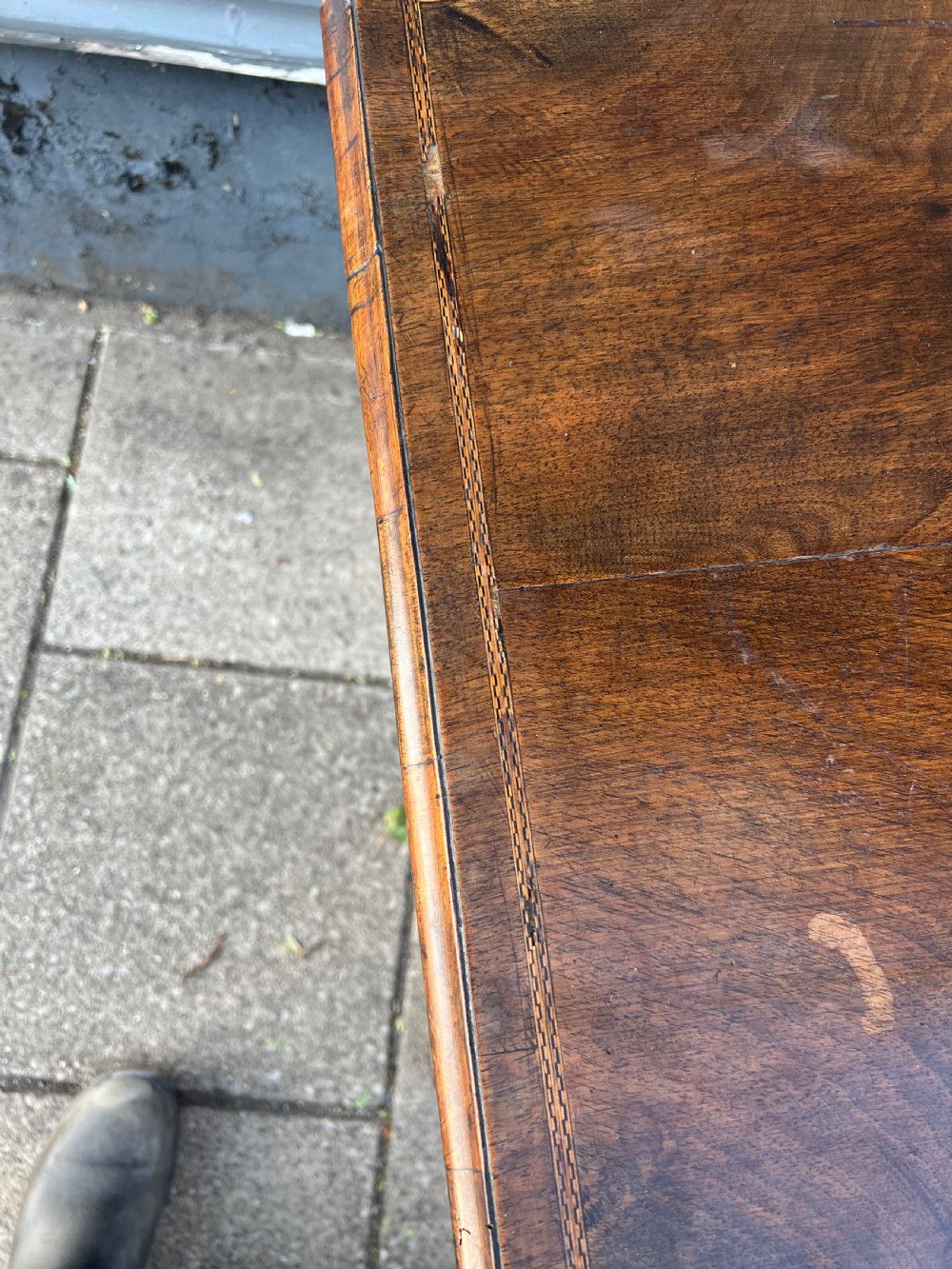 An early Georgian walnut side table with a single drawer, brass handles, shaped apron, and four cabriole legs. View IX