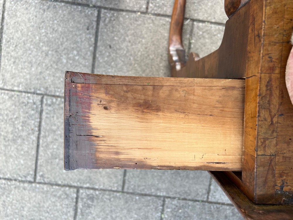 An early Georgian walnut side table with a single drawer, brass handles, shaped apron, and four cabriole legs. View XIV