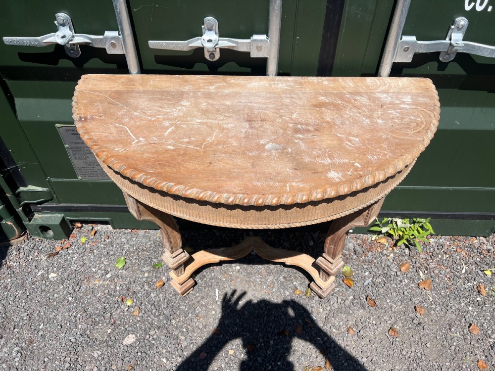 An overhead view of a semicircular carved oak console table featuring detailed fluting and scroll legs. View V