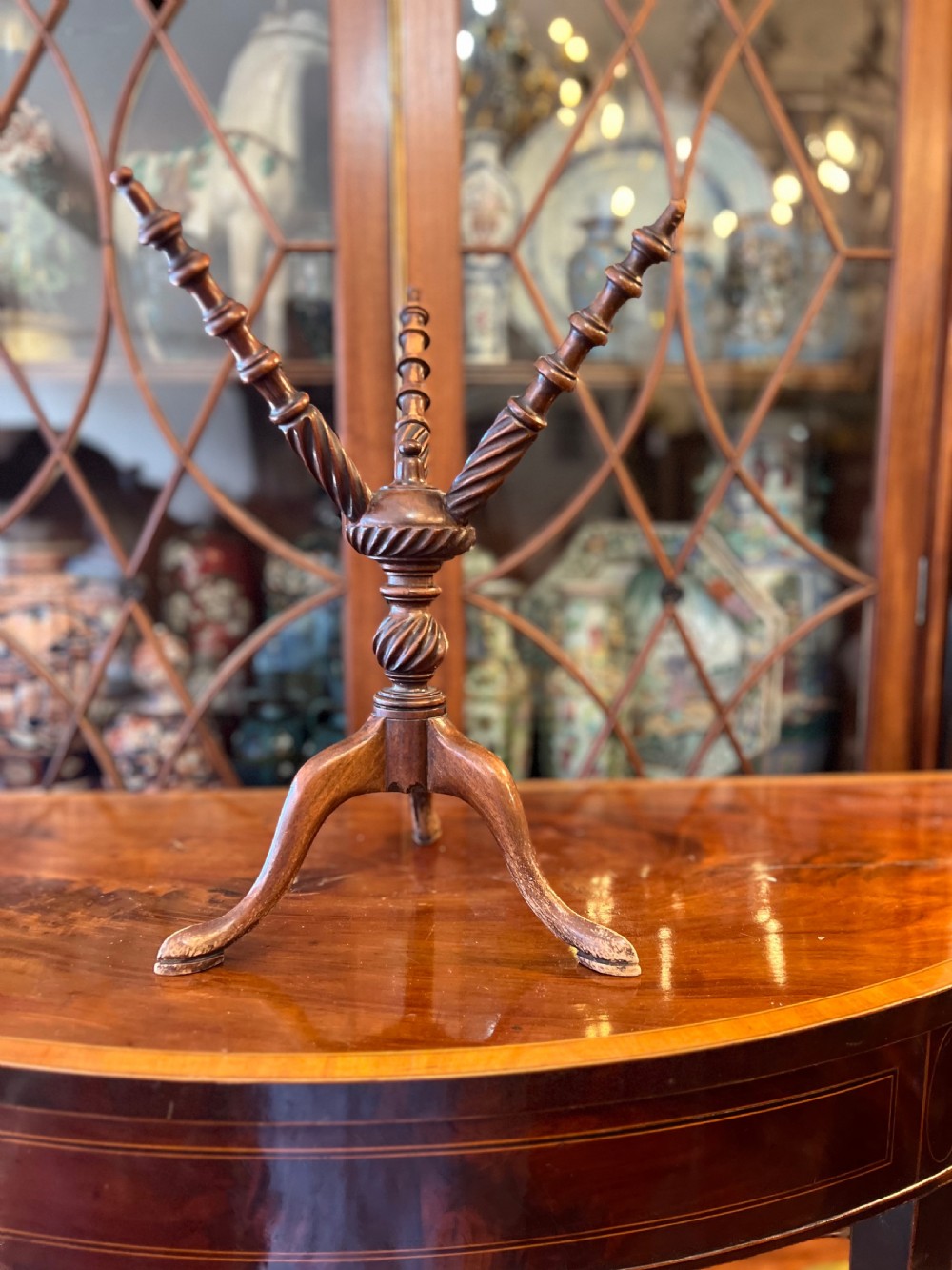 An early nineteenth-century turned wood treen plate stand featuring three spiral-carved upper arms above a turned central column and tripod base. View II