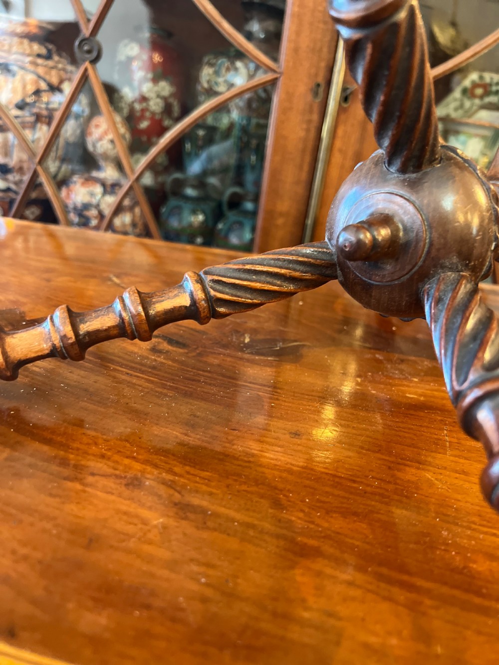 An early nineteenth-century turned wood treen plate stand featuring three spiral-carved upper arms above a turned central column and tripod base. View V