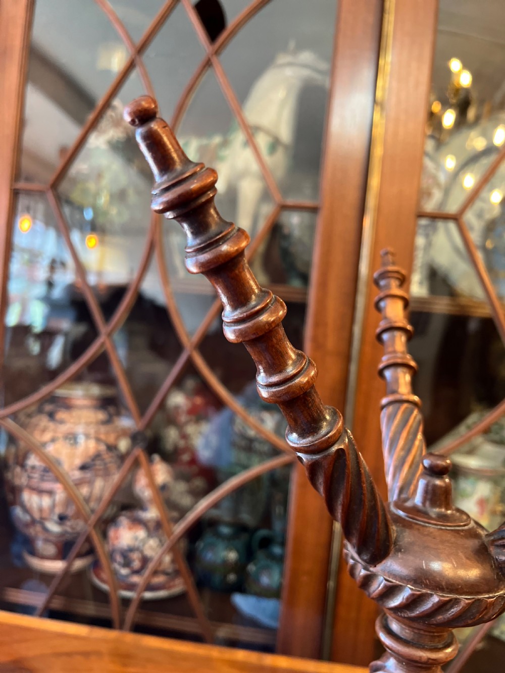An early nineteenth-century turned wood treen plate stand featuring three spiral-carved upper arms above a turned central column and tripod base. View VII