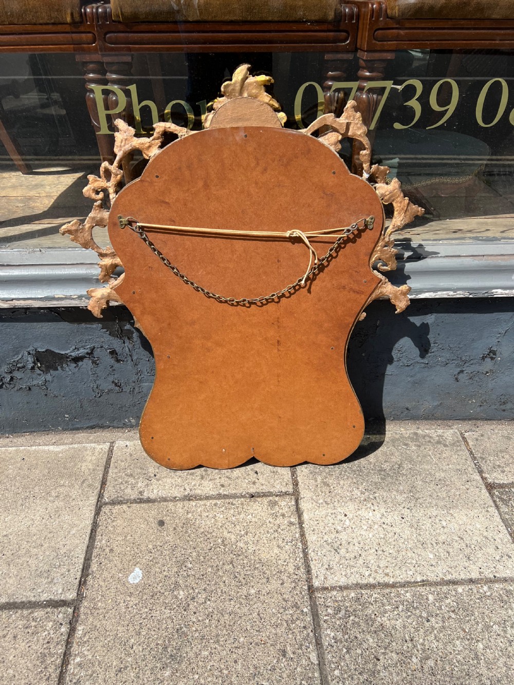 An ornate Rococo style wall mirror with a carved giltwood frame featuring elaborate acanthus leaf scrolls and a top cresting. View IV