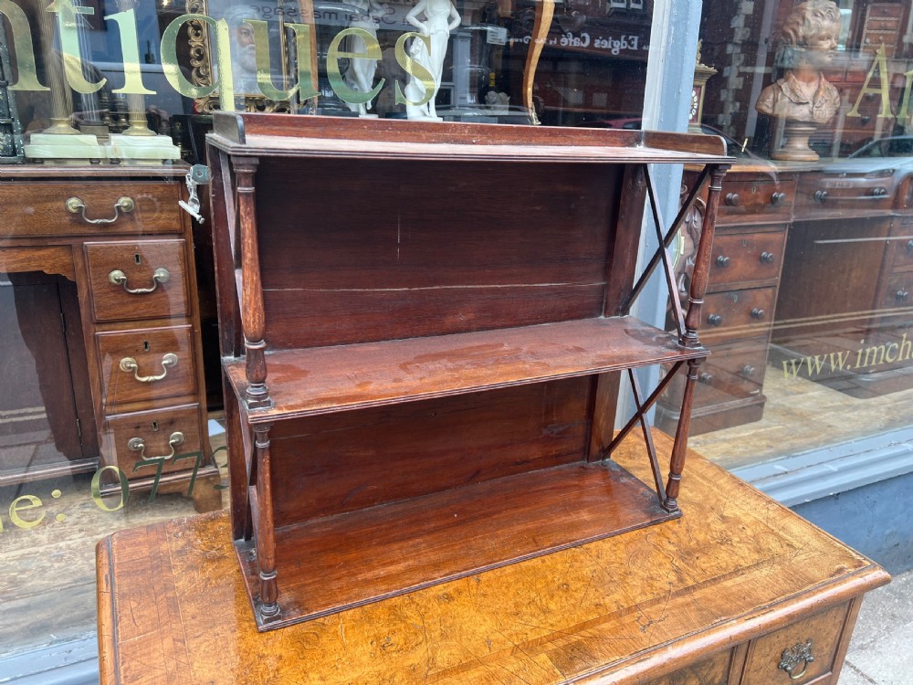 A three-tier Georgian mahogany wall shelf featuring turned spindle supports and open X-frame sides. View II