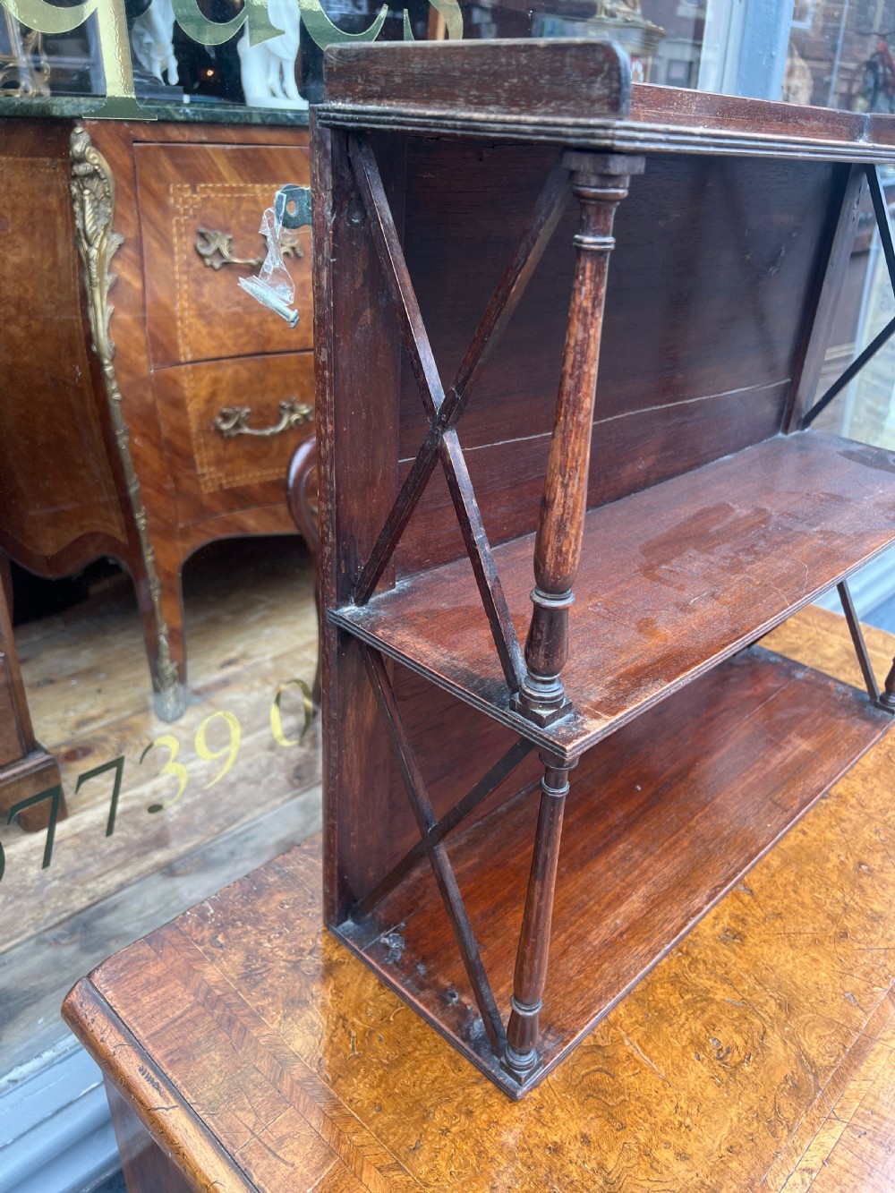 A three-tier Georgian mahogany wall shelf featuring turned spindle supports and open X-frame sides. View III