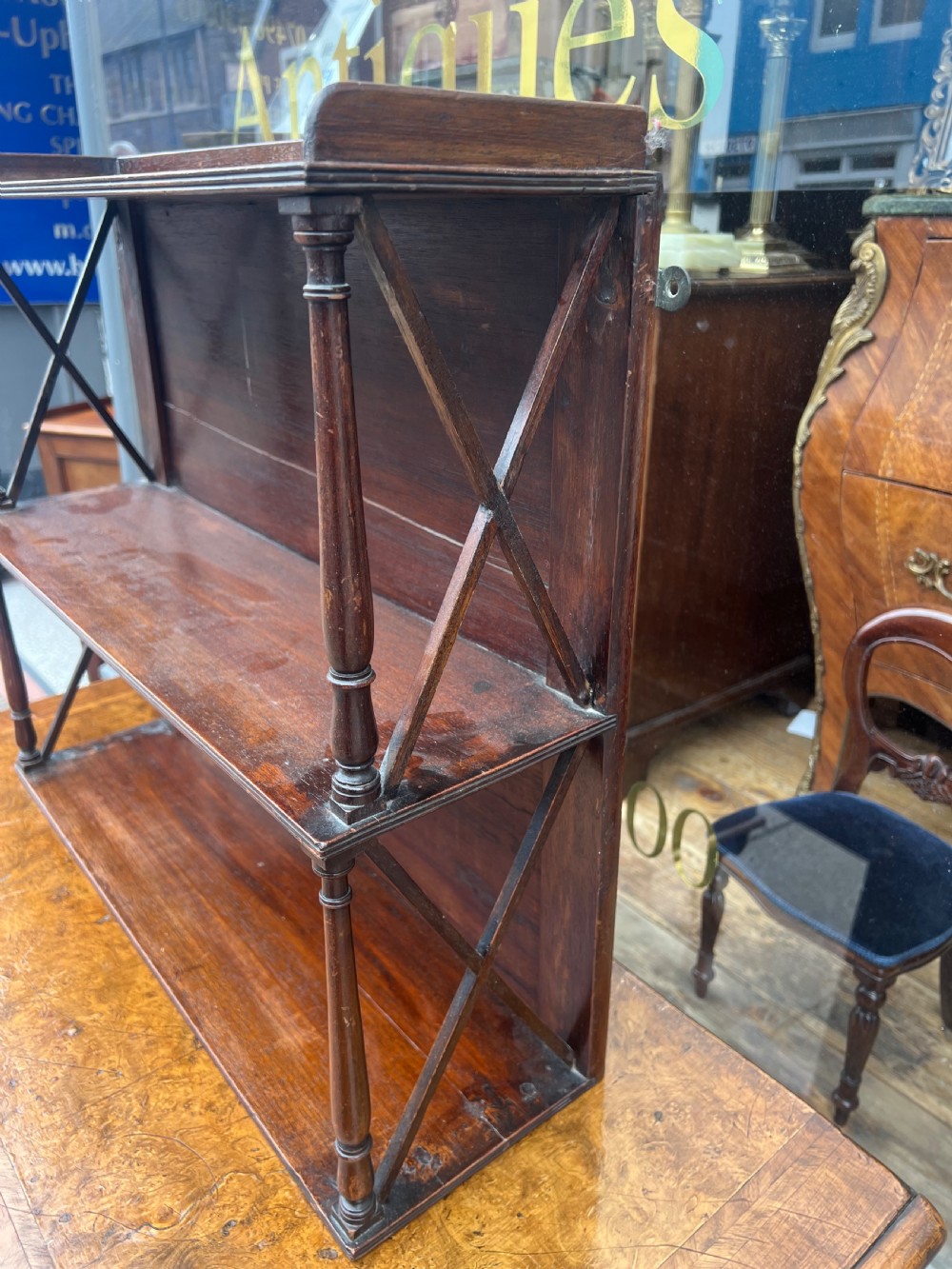 A three-tier Georgian mahogany wall shelf featuring turned spindle supports and open X-frame sides. View V