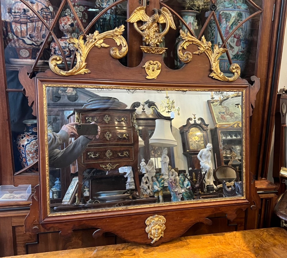 An Edwardian mahogany fretwork wall mirror featuring an ornate parcel gilt eagle finial and classical mask motif. View II