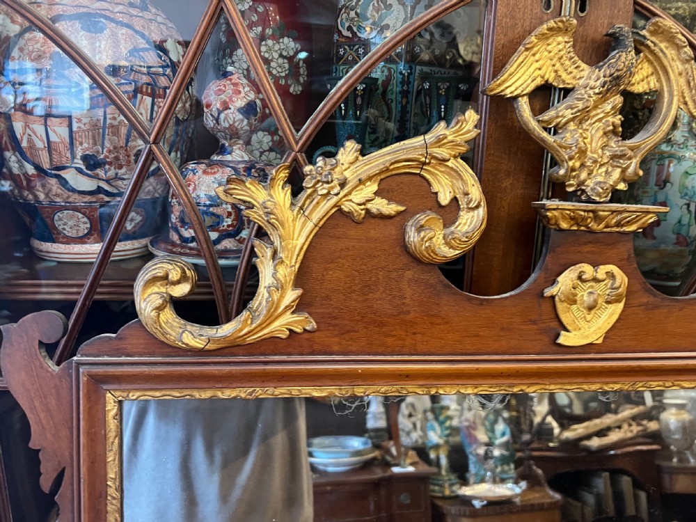 An Edwardian mahogany fretwork wall mirror featuring an ornate parcel gilt eagle finial and classical mask motif. View III
