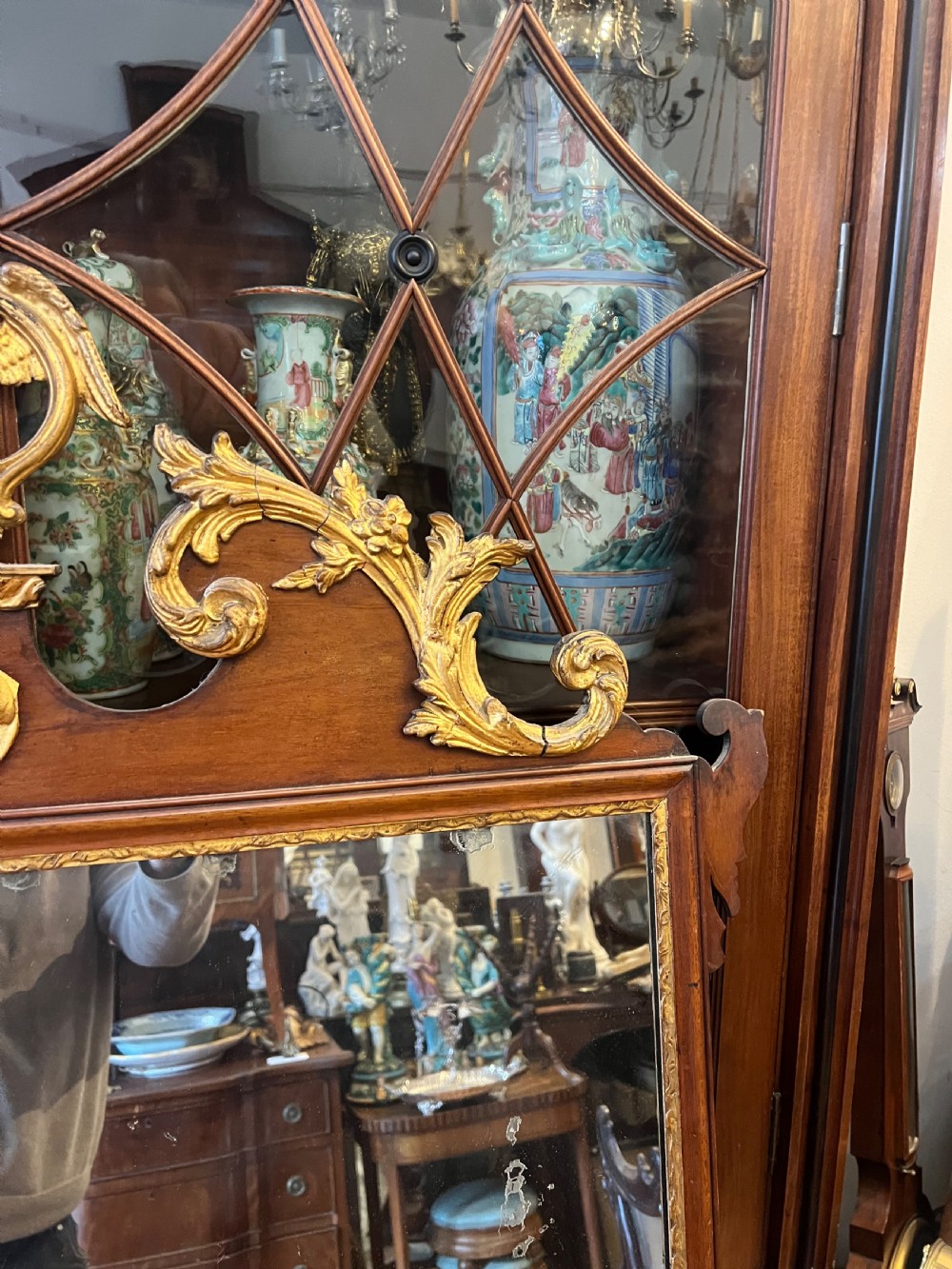 An Edwardian mahogany fretwork wall mirror featuring an ornate parcel gilt eagle finial and classical mask motif. View V