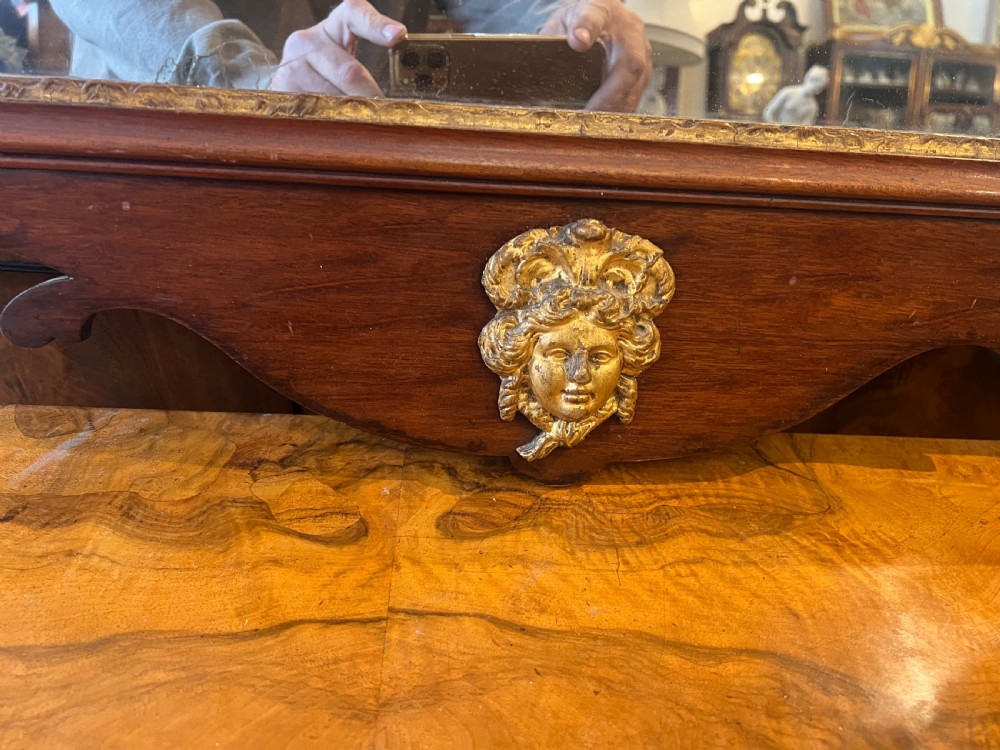 An Edwardian mahogany fretwork wall mirror featuring an ornate parcel gilt eagle finial and classical mask motif. View VI