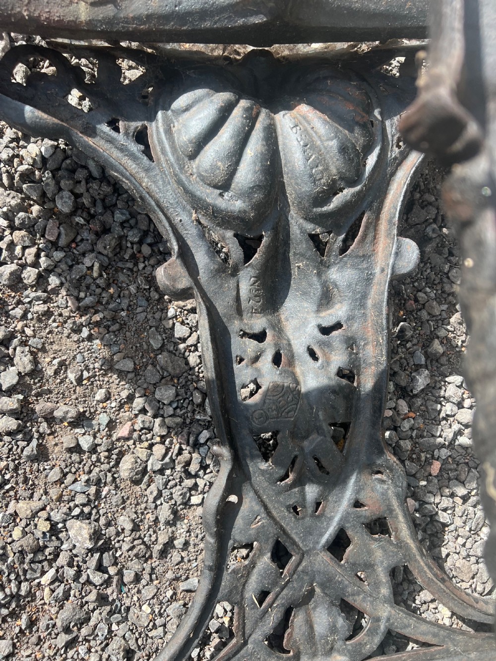 An ornate nineteenth-century black cast iron umbrella and stick stand featuring openwork scrolling and a lower drip tray. View V