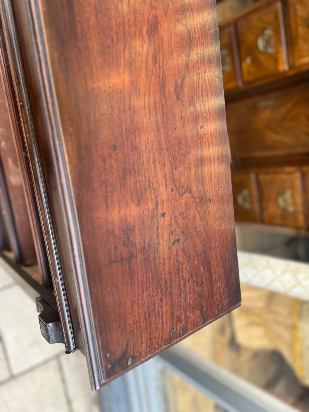 An Edwardian open walnut bookcase featuring four adjustable wooden shelves, side corbel carvings, and a solid plinth base. View VII