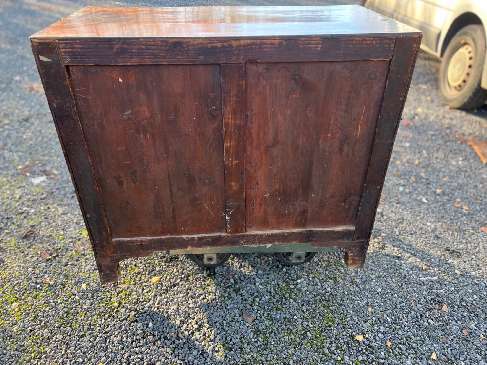 A George III mahogany chest of drawers featuring a serpentine front, line inlay, two short over three long drawers, and brass ring handles. View II