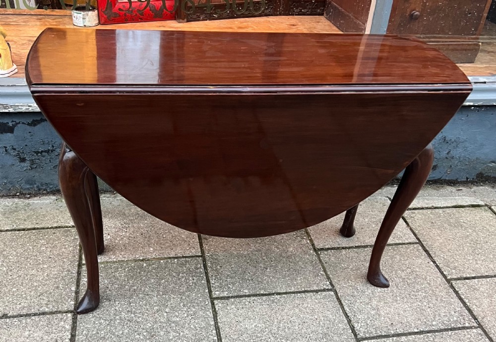 An 18th-century Cuban mahogany drop leaf table with curved cabriole legs and carved pointed pad feet. View III