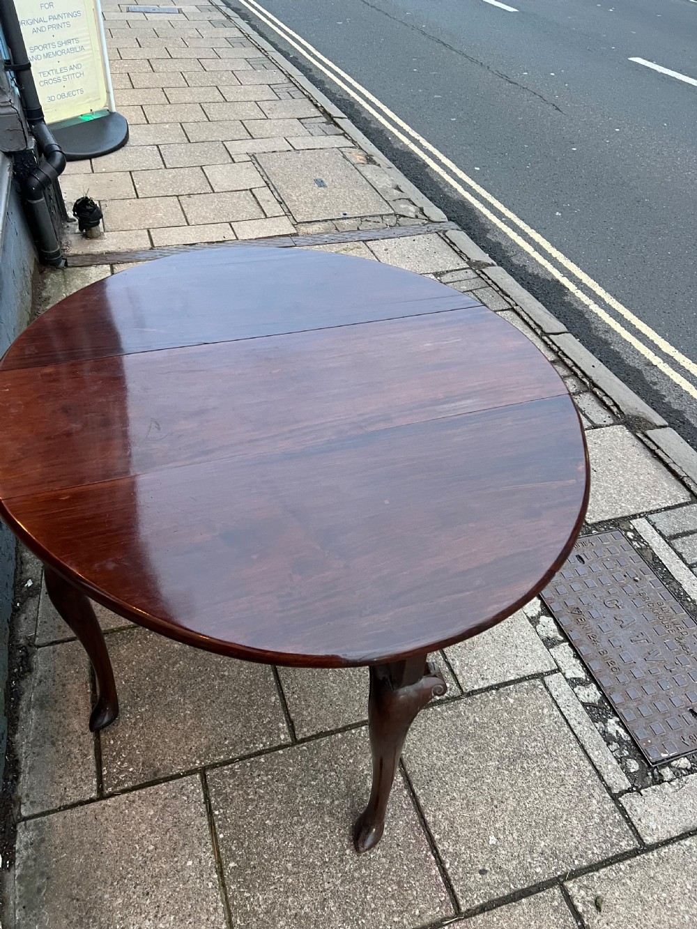 An 18th-century Cuban mahogany drop leaf table with curved cabriole legs and carved pointed pad feet. View IV