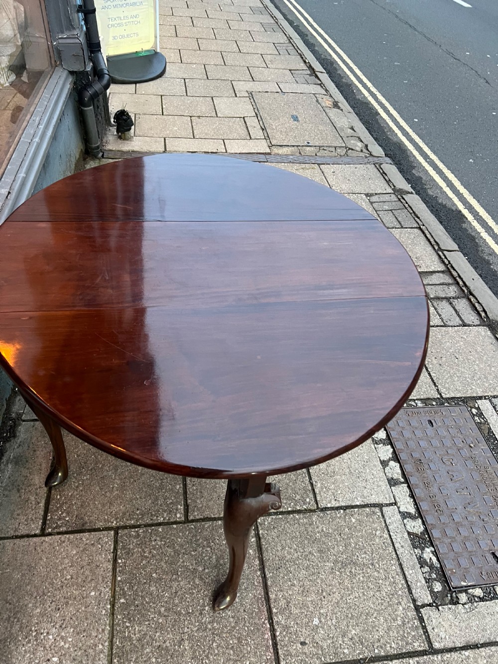 An 18th-century Cuban mahogany drop leaf table with curved cabriole legs and carved pointed pad feet. View V