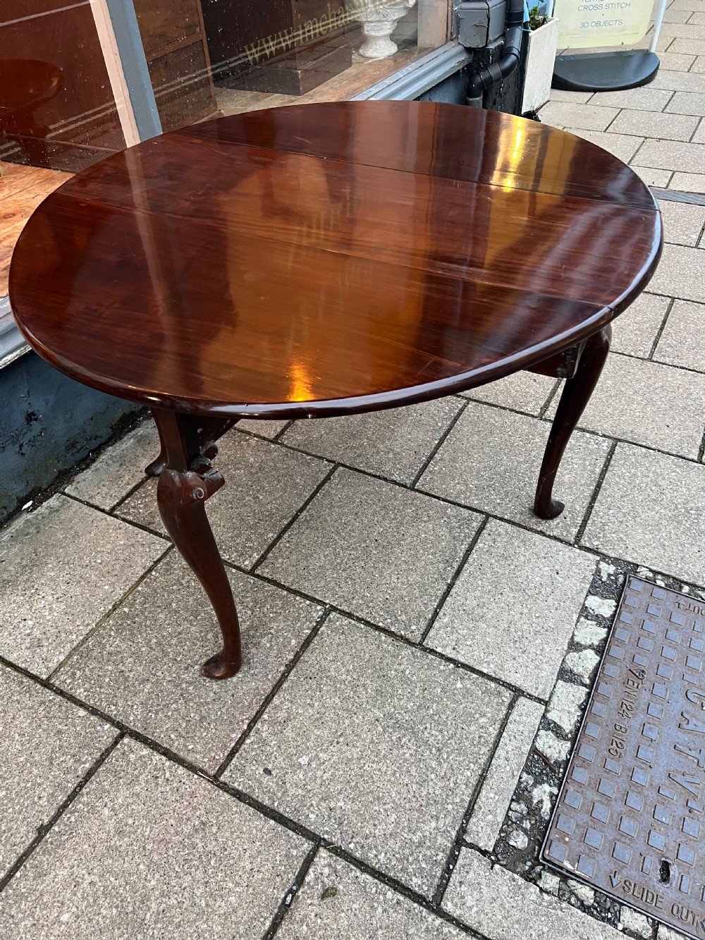 An 18th-century Cuban mahogany drop leaf table with curved cabriole legs and carved pointed pad feet. View VI