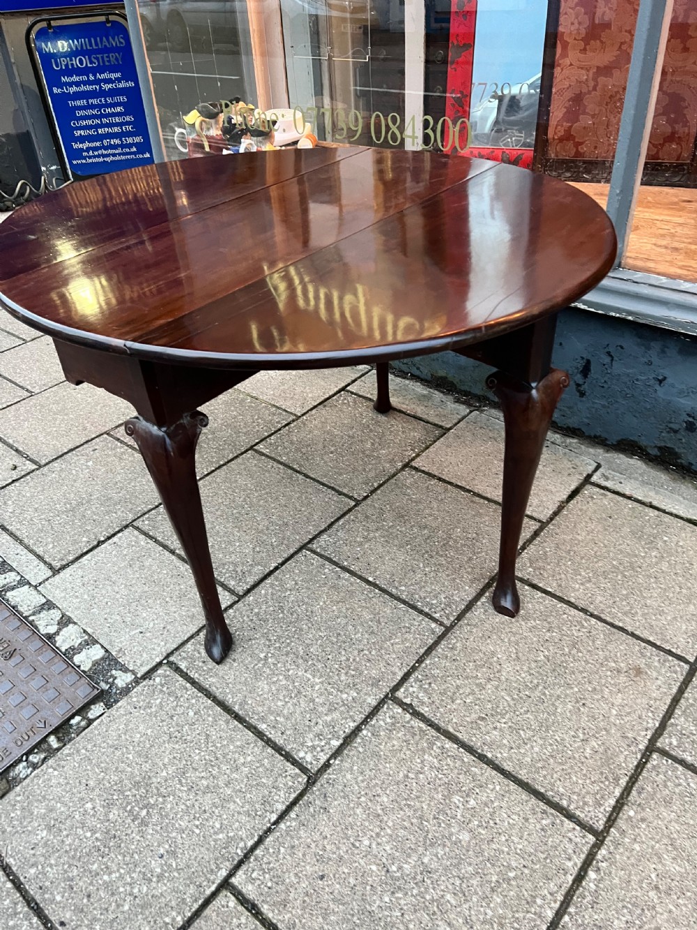 An 18th-century Cuban mahogany drop leaf table with curved cabriole legs and carved pointed pad feet. View VII
