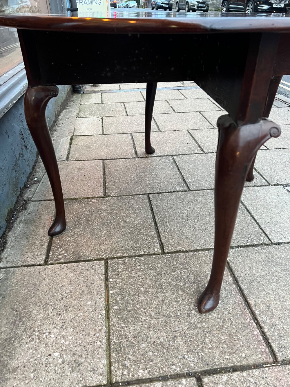 An 18th-century Cuban mahogany drop leaf table with curved cabriole legs and carved pointed pad feet. View XIII