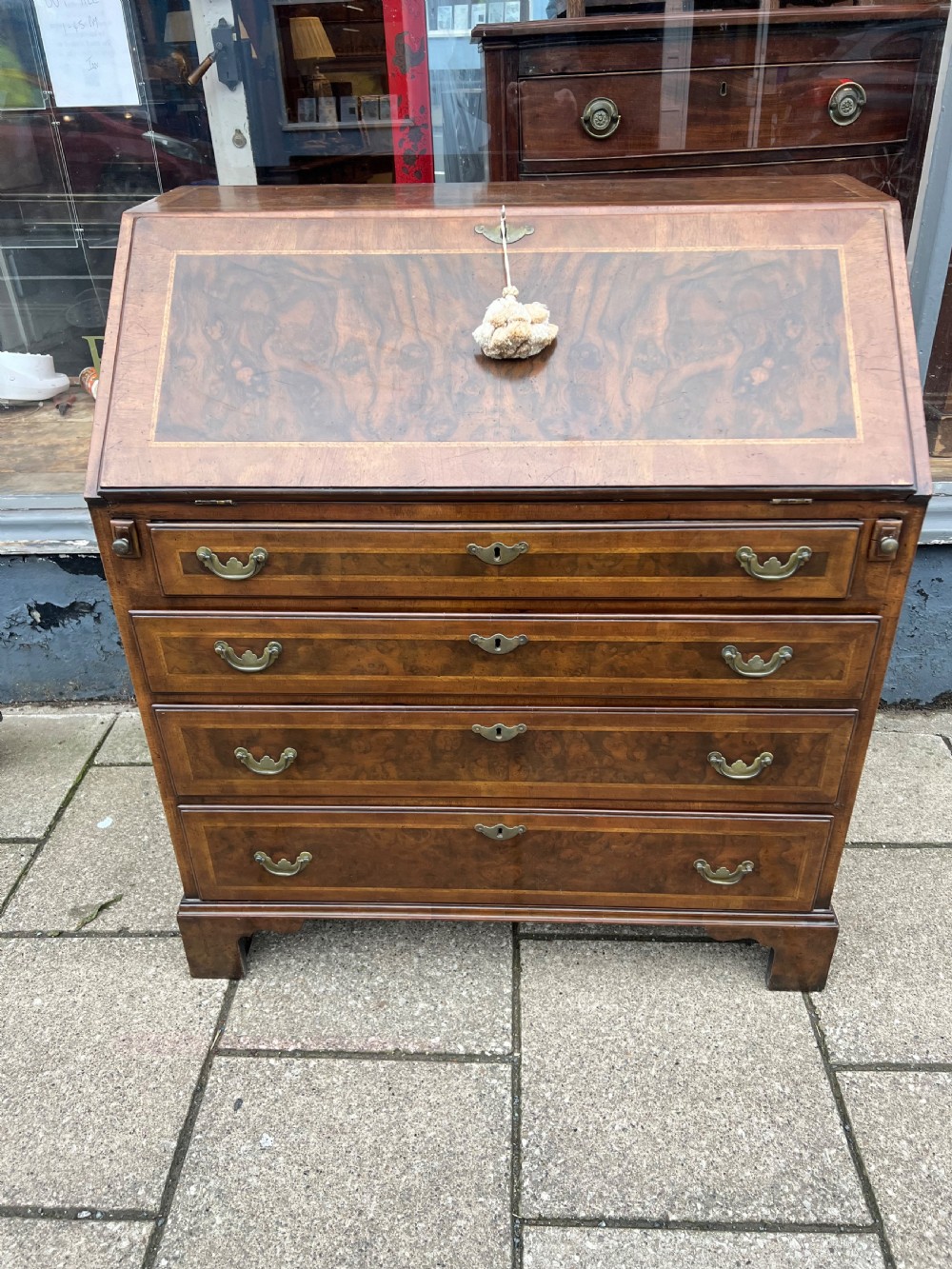 An 18th-century walnut and burr walnut slant-front bureau featuring crossbanded drawers, brass drop handles, and bracket feet. View II