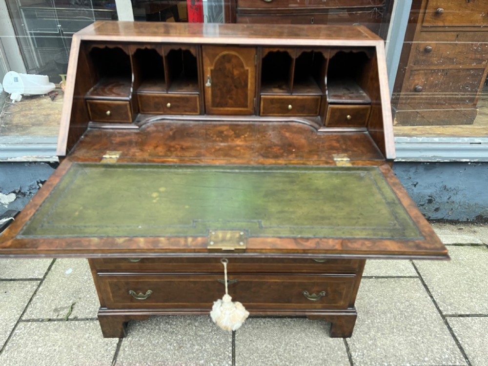 An 18th-century walnut and burr walnut slant-front bureau featuring crossbanded drawers, brass drop handles, and bracket feet. View III