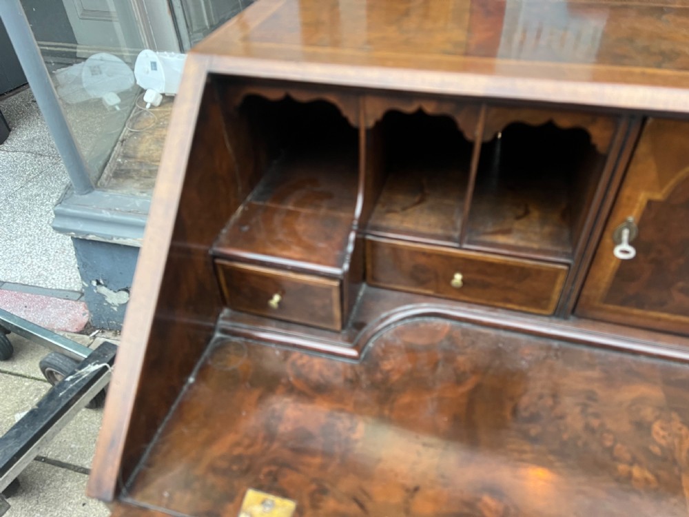 An 18th-century walnut and burr walnut slant-front bureau featuring crossbanded drawers, brass drop handles, and bracket feet. View IV