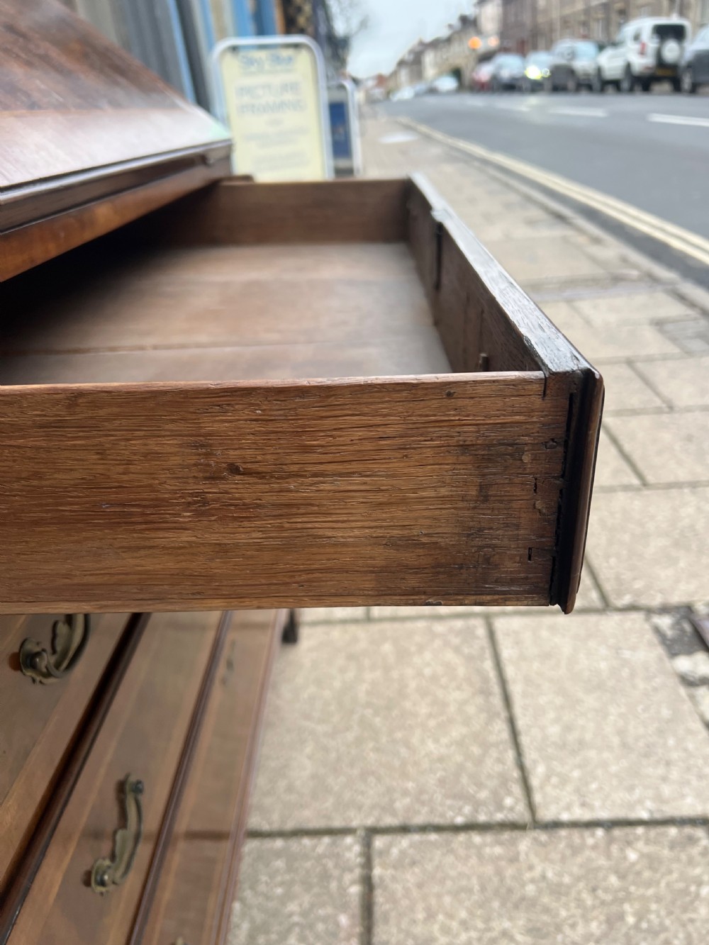 An 18th-century walnut and burr walnut slant-front bureau featuring crossbanded drawers, brass drop handles, and bracket feet. View X