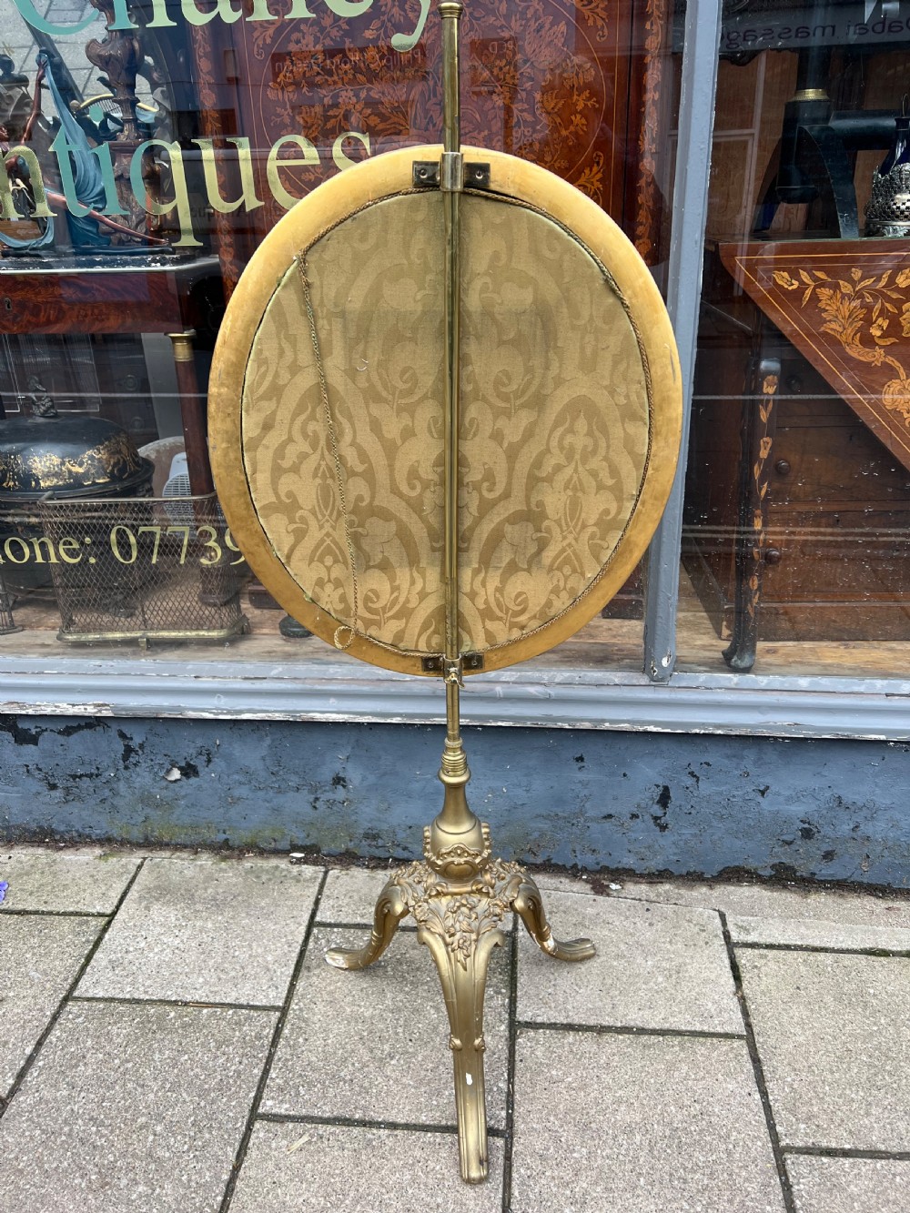A 19th-century gilded pole screen with a tripod Rococo base framing an oval needlepoint panel depicting flowers and a bird. View V