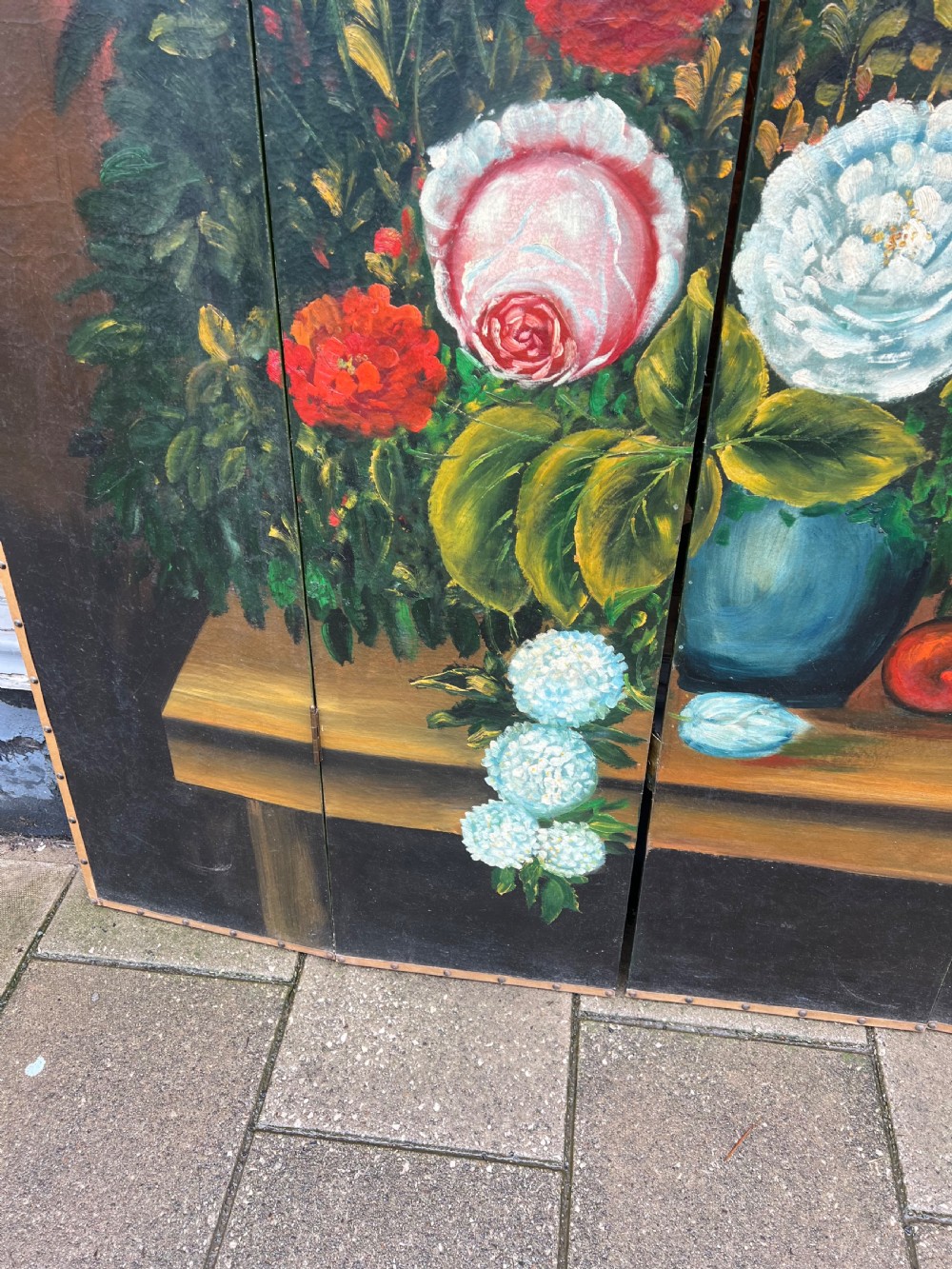 A four-panel arched folding screen featuring a large hand-painted floral still life in a blue vase set on a wooden table surface against a warm brown background. View III
