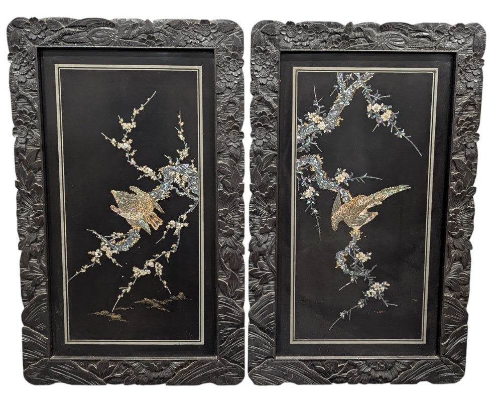 A pair of rectangular black lacquered panels featuring mother of pearl and abalone shell inlay depicting birds on flowering branches, set within deeply carved dark wood frames.
