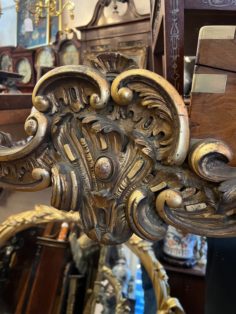A 19th-century carved giltwood pier mirror featuring a Rococo cresting, scrolling acanthus leaf details, and an arched upper frame. View VIII