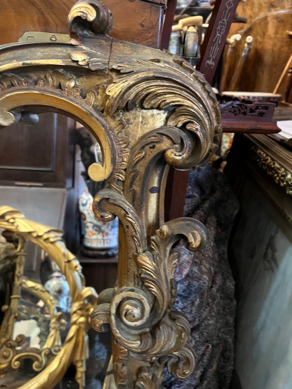 A 19th-century carved giltwood pier mirror featuring a Rococo cresting, scrolling acanthus leaf details, and an arched upper frame. View IX