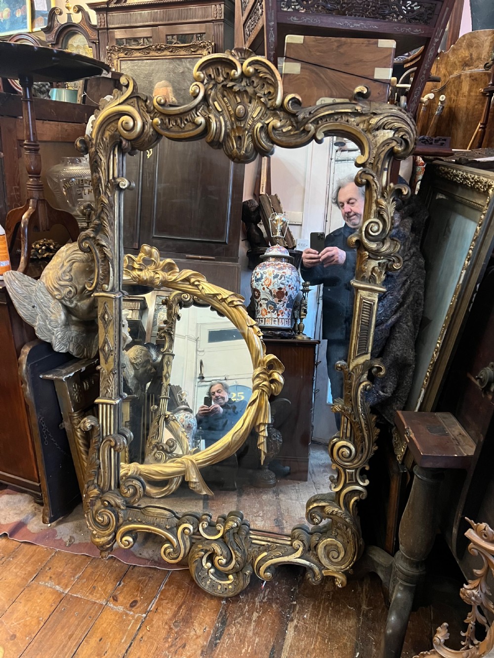 A 19th-century carved giltwood pier mirror featuring a Rococo cresting, scrolling acanthus leaf details, and an arched upper frame. View X