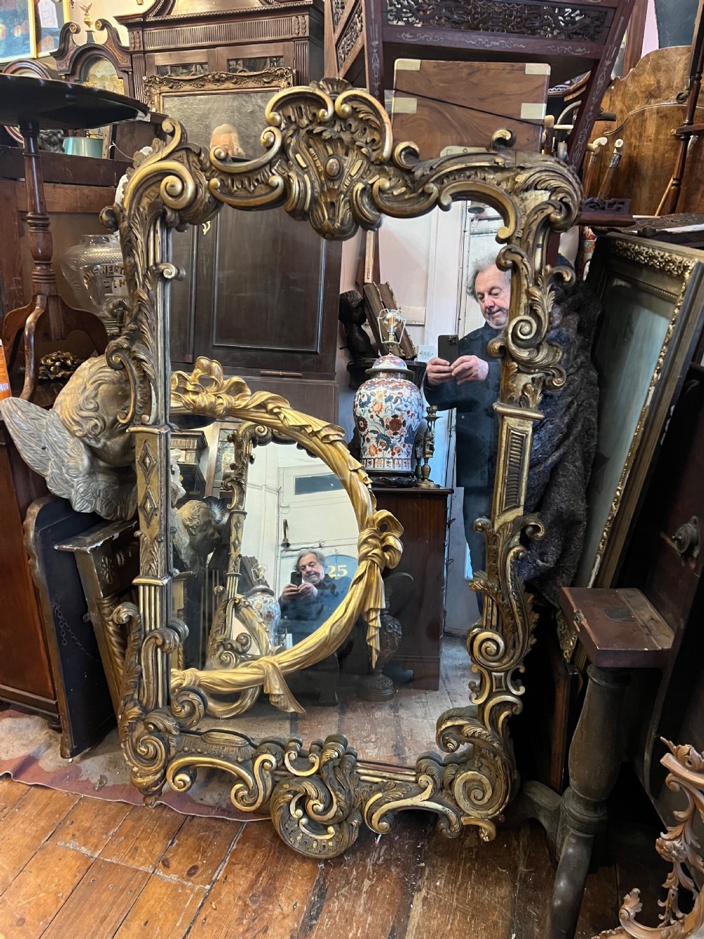 A 19th-century carved giltwood pier mirror featuring a Rococo cresting, scrolling acanthus leaf details, and an arched upper frame. View XI